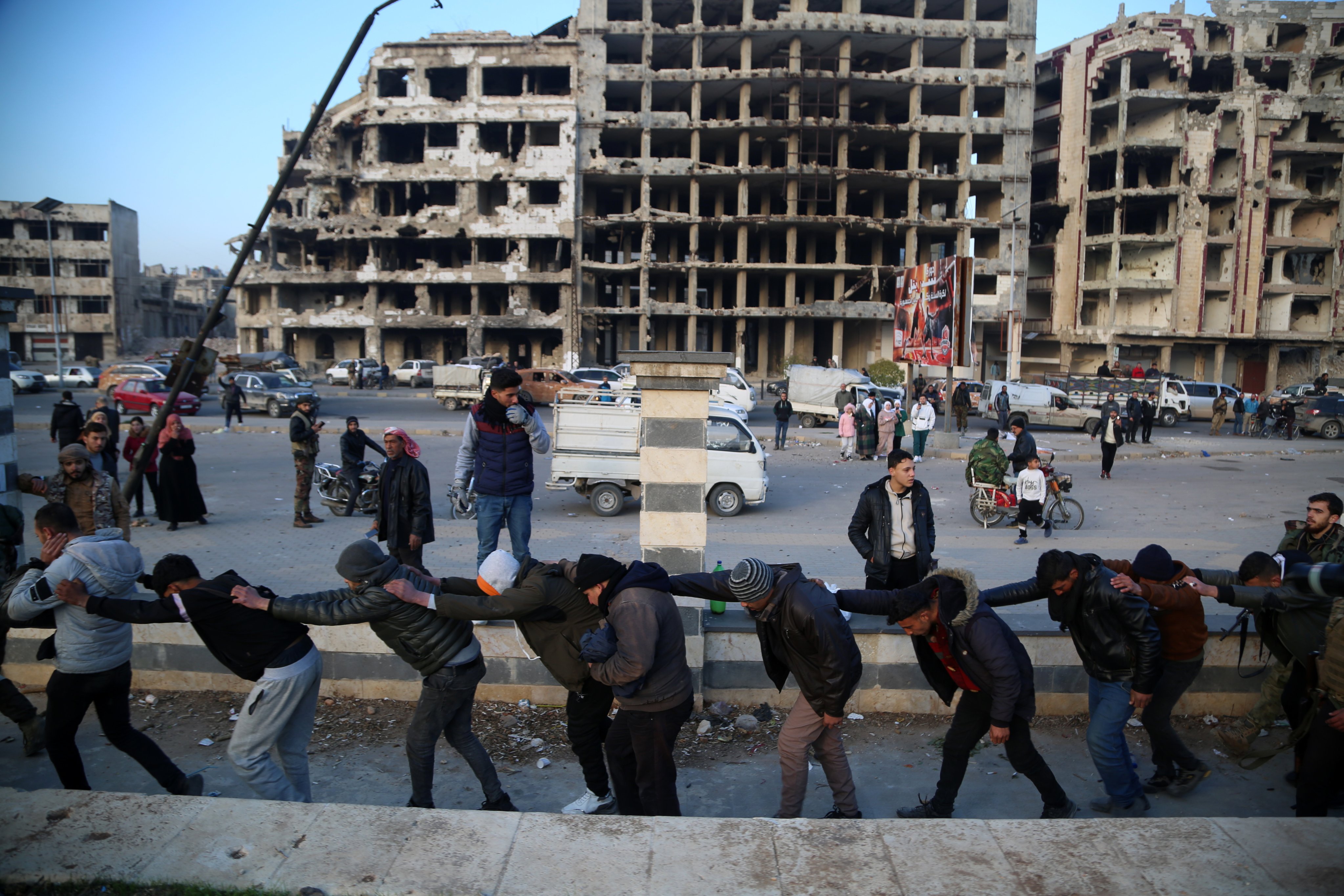 Syrian regime soldiers are led by rebel soldiers as people look on in Homs, Syria. Photo: EPA-EFE
